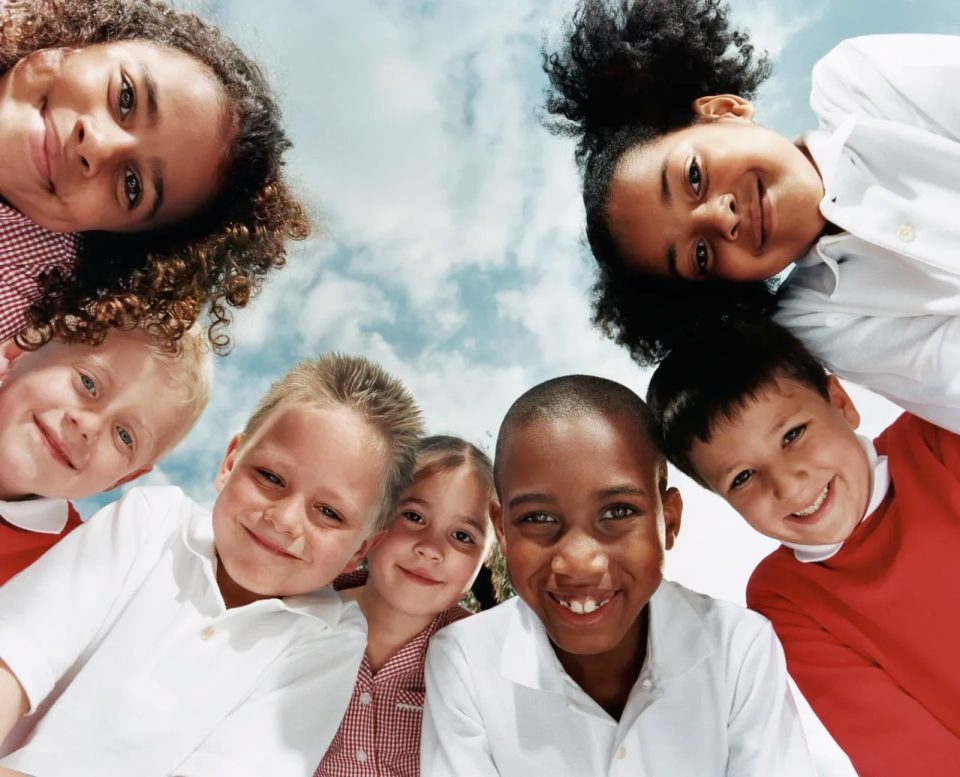 7 kids in a circle looking down at the camera